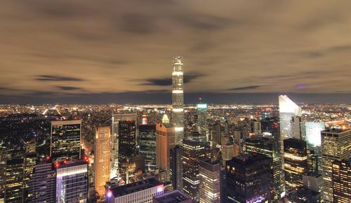 Illuminated cityscape against sky at night