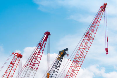 Crawler crane against blue sky and white clouds. real estate industry. red crawler crane.