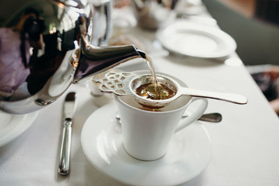 Pouring tea through a tea strainer