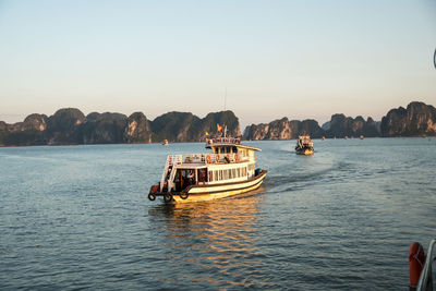 Boat sailing in sea against clear sky