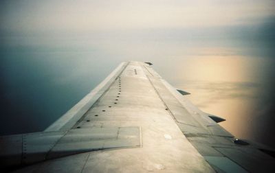 Airplane flying over sea against sky