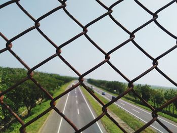 Close-up of chainlink fence against sky