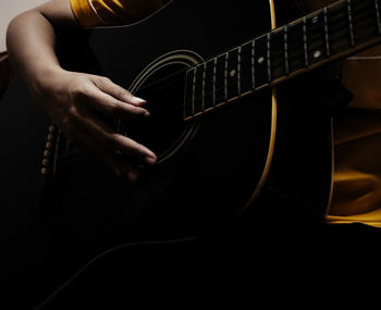 Midsection of man playing guitar