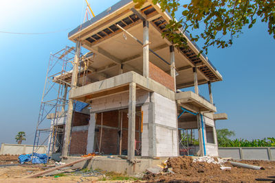 Low angle view of abandoned building against clear blue sky