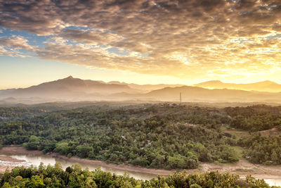 Sunrise of a river and hills in kandy - sri lanka with mist and fog atmosphere 