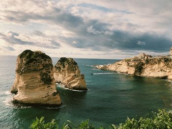 Rock formation in sea against sky