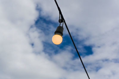 Low angle view of light bulb against sky