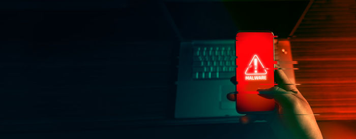 Close-up of hand holding red light against the wall