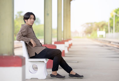 Depressed young man sitting on railway track person