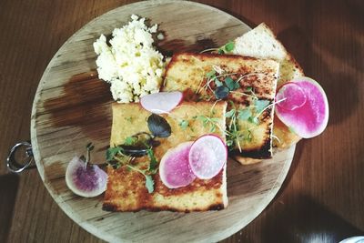 High angle view of open faced sandwiches on cutting board