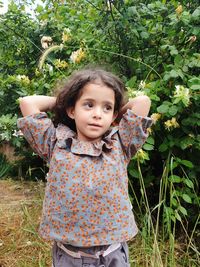 Portrait of cute girl standing by plants