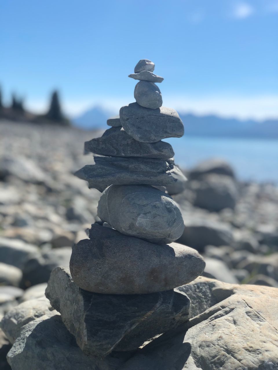 STACK OF PEBBLES ON ROCK IN SEA