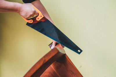 Cropped hands of carpenter cutting wood