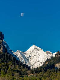 Scenic view of snowcapped mountains against blue sky