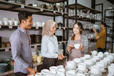 Portrait of smiling friends standing in store