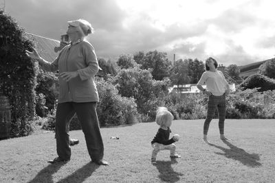 Rear view of siblings standing against trees