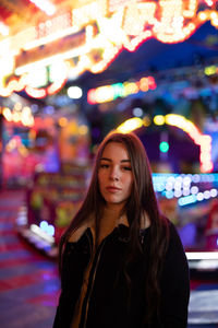 Portrait of smiling young woman standing in amusement park