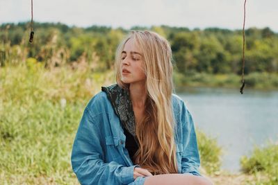 Portrait of young woman sitting on field