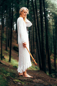 Portrait of young woman standing in forest