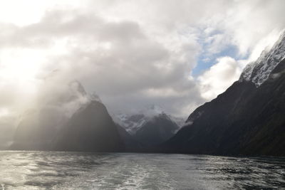 Scenic view of sea and mountains against sky