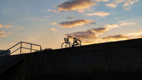 Low angle view of silhouette bicycle against building