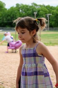 Girl looking away while standing at playground