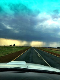 Road passing through landscape against cloudy sky