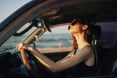 Young woman sitting in car