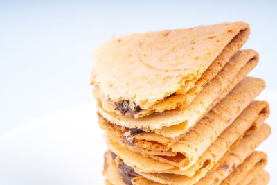 Close-up of bread on plate against white background