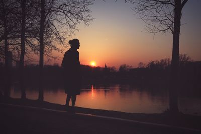 Silhouette people on landscape at sunset