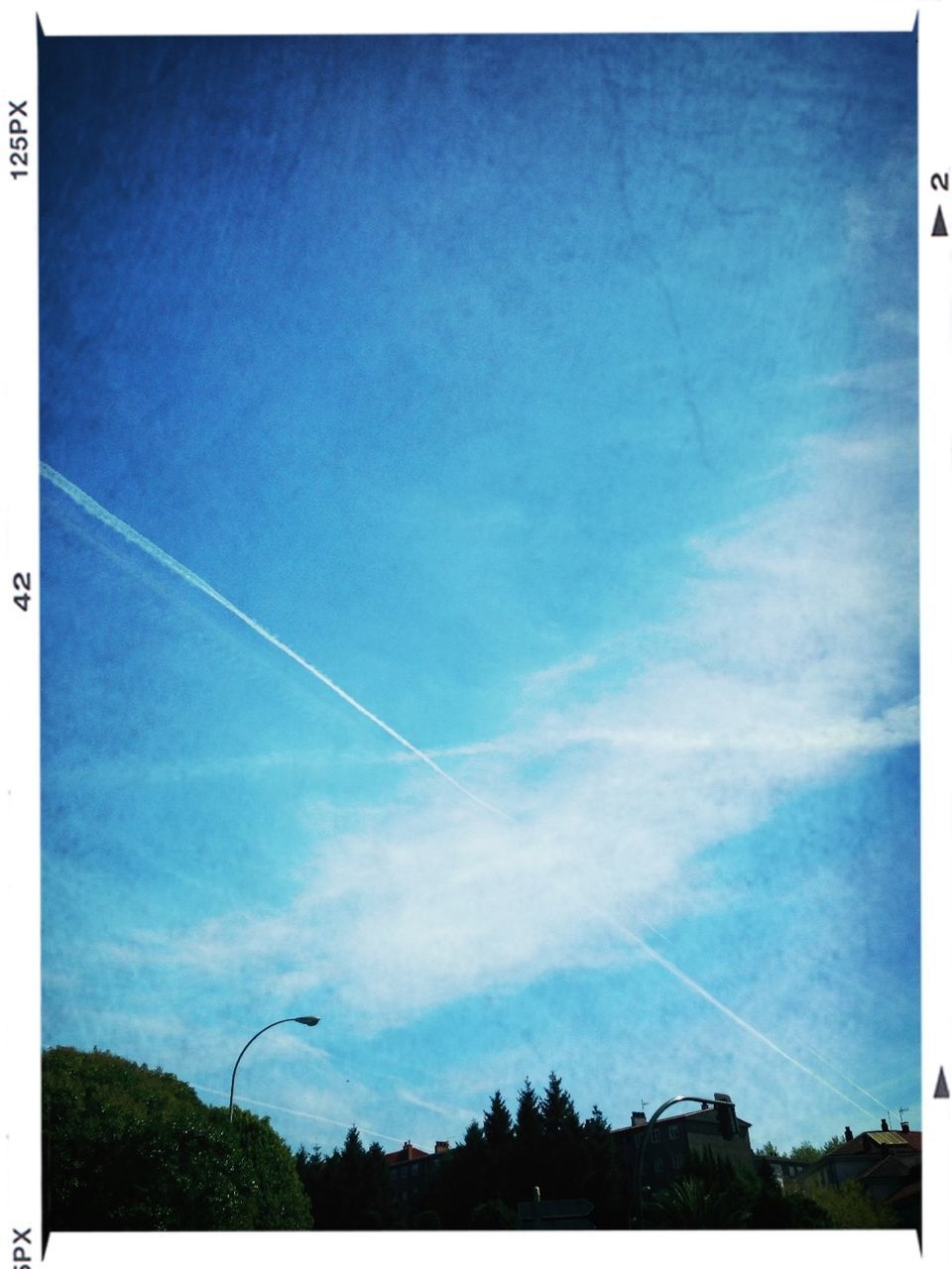 transfer print, low angle view, sky, blue, tree, auto post production filter, tranquility, beauty in nature, vapor trail, power line, cloud - sky, nature, scenics, tranquil scene, cloud, outdoors, no people, day, electricity, electricity pylon