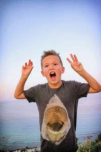 Portrait of boy on beach against clear sky