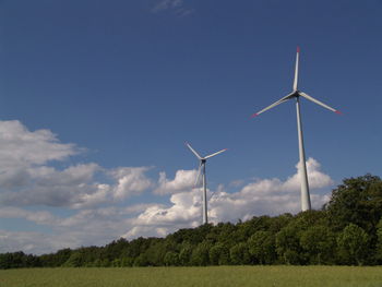 Low angle view of windmill on field against sky