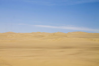 Scenic view of desert against blue sky