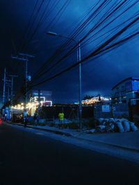 Illuminated street in city at night during winter