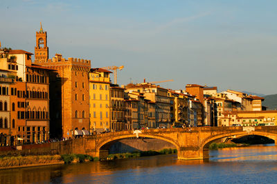 Bridge over river against buildings in city