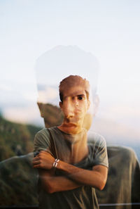 Portrait of young man standing against sky