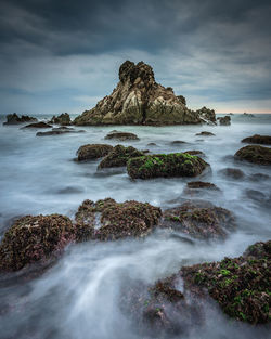 Scenic view of rocks in sea against sky