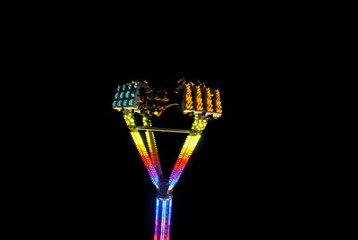 Close-up of illuminated lighting equipment against black background