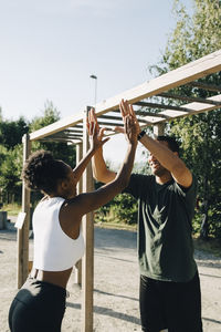 Male and female athlete giving high-five at park
