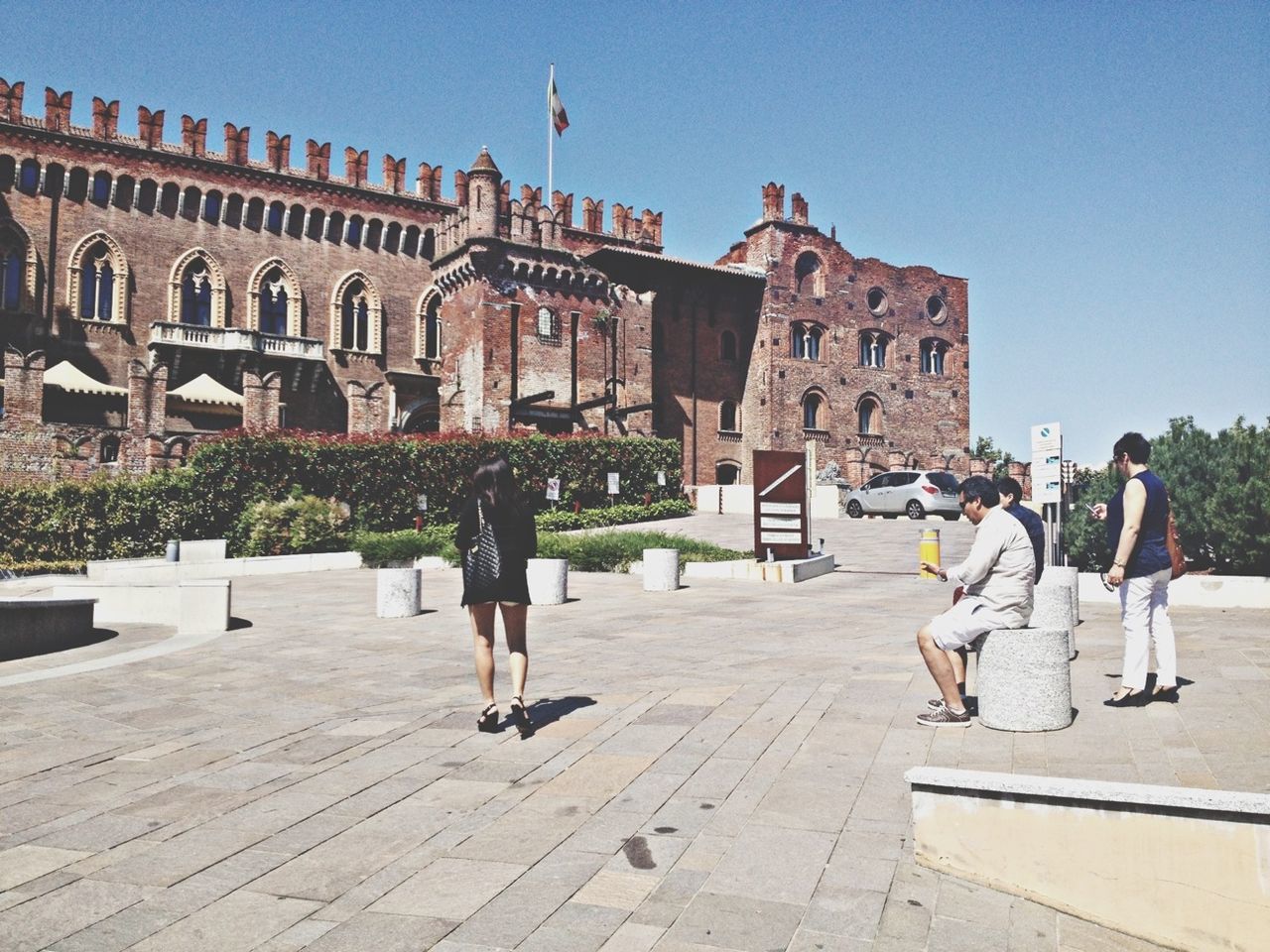 architecture, building exterior, built structure, full length, lifestyles, men, person, walking, leisure activity, city, sunlight, casual clothing, sky, street, rear view, city life, cobblestone, shadow, day