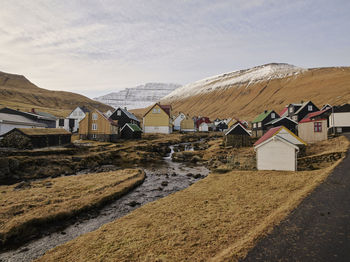 Scenic view of village by houses against sky