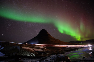 Scenic view of illuminated mountain against sky at night