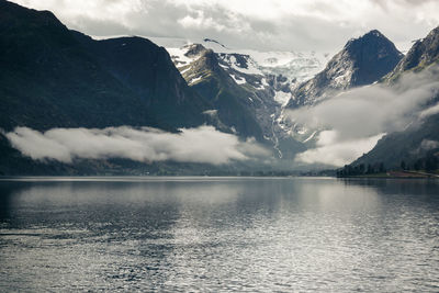 Scenic view of lake by mountains against sky