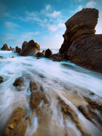 Rock formations in sea against sky