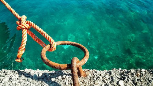 Rope tied on rusty mooring ring at harbor