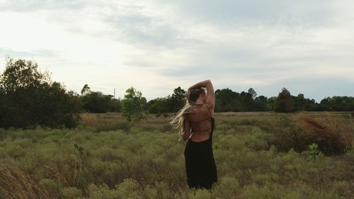 Rear view of woman standing on field