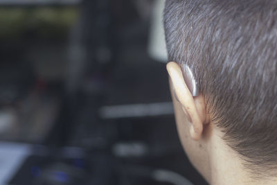 Close-up of man with hearing aid at home