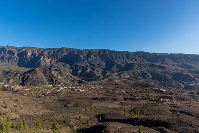 Scenic view of mountains against clear blue sky