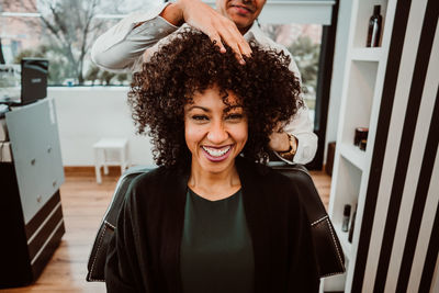 Midsection of barber massaging woman hair in salon